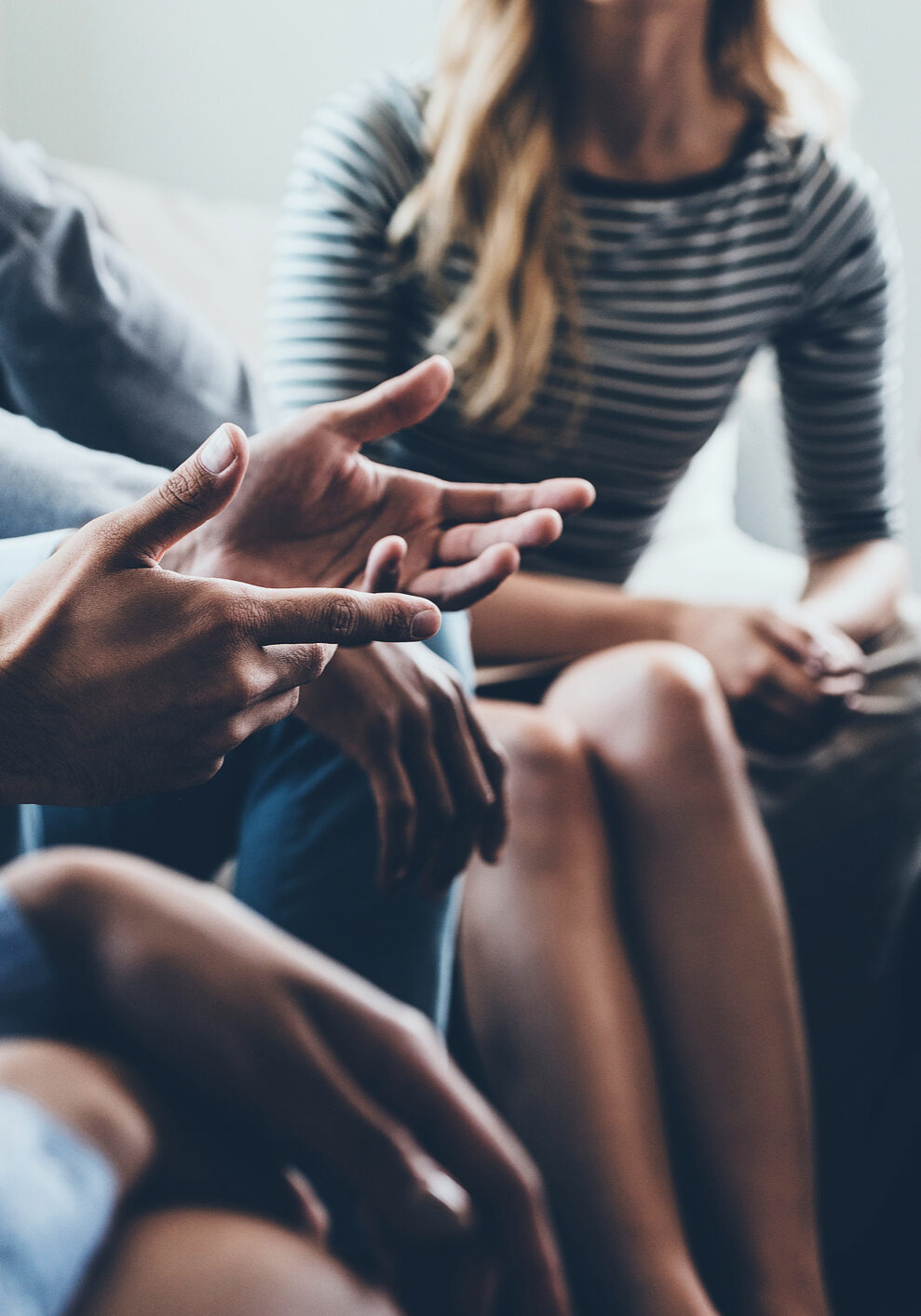 Close-up of people communicating while sitting in circle and gesturing